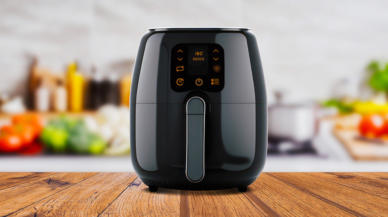 An air fryer on a wooden counter.