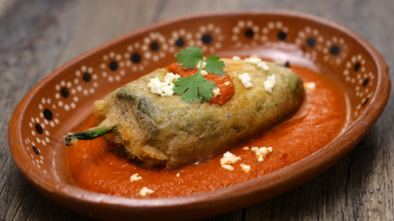 Chile Relleno topped with cheese and cilantro.