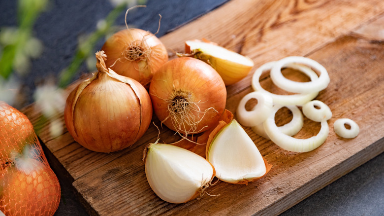 Yellow onions chopped on wooden cutting board.