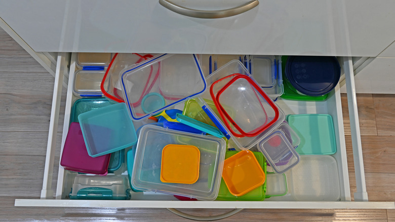 Messy drawer filled with plastic containers