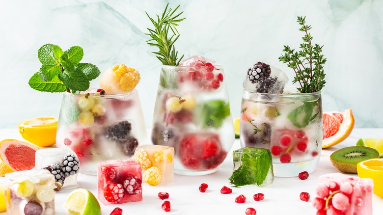 Ice cubes with frozen fruit and herbs
