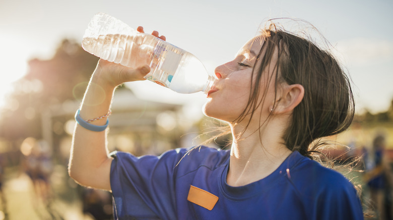 Child drinking from plastic water bottle 