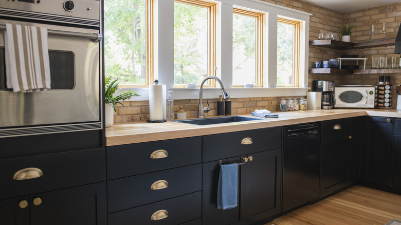 A kitchen with dark blue painted cabinets.