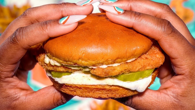 Hands holding the Flounder Fish Sandwich from Popeyes