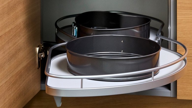 A pull-out kitchen shelf installed in a low, corner cabinet