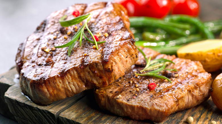 Grilled beef steaks on a wooden cutting board