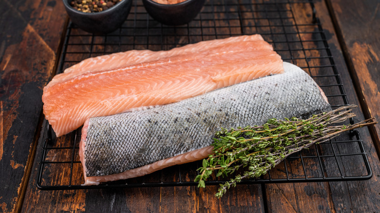 Raw salmon fillets are placed face up and face down to show skin-on and skinless style.