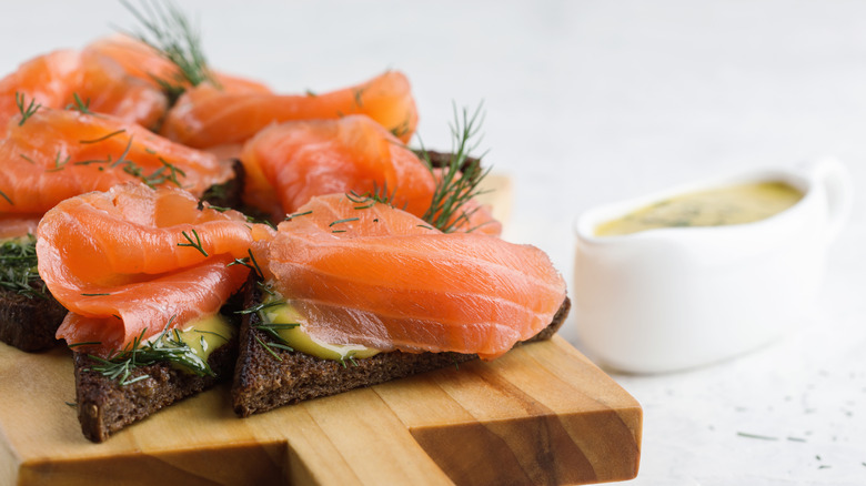Pieces of toast are topped with smokes salmon and sauce.