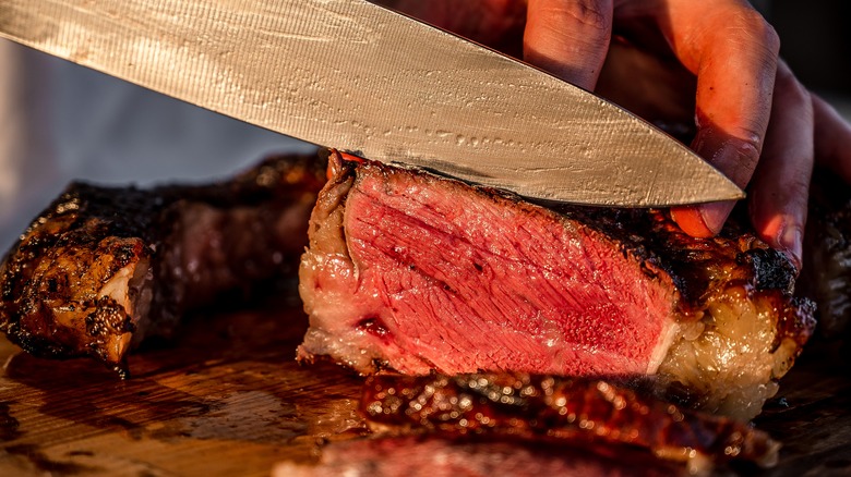 Carving cooked rare steak 