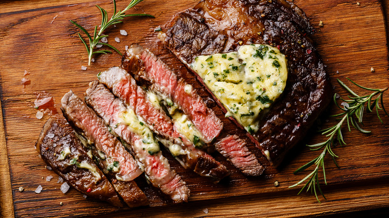 Cooked, sliced ribeye with compound butter