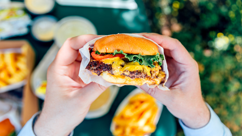 two hands holding a burger