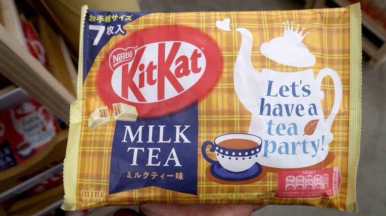 An international Kit Kat flavor, Milk Tea, is held by a customer inside of a store