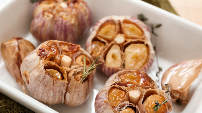 A tray of roasted garlic with herbs