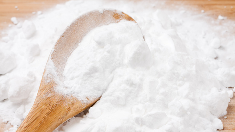 Wooden spoon in pile of baking powder