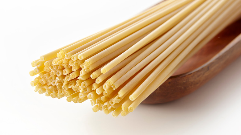 Uncooked bucatini pasta on a dish