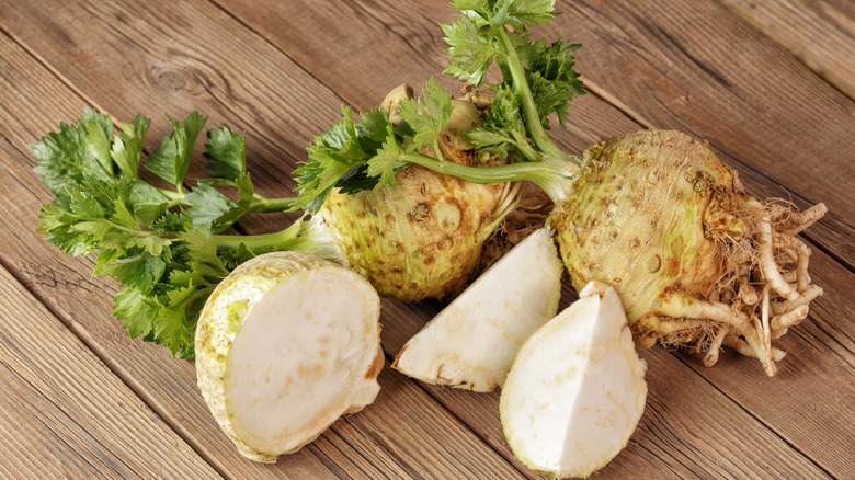 Several celeriac root vegetables, one cut in three pieces