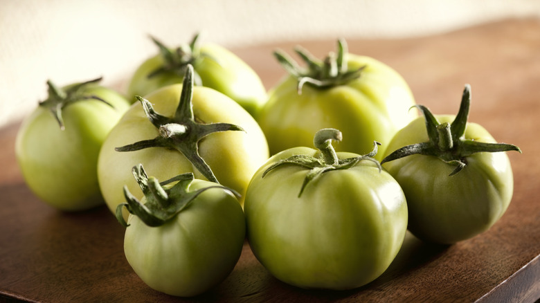 green tomatoes sitting on a table