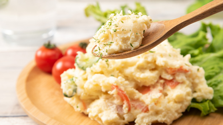 A spoonful of potato salad lightly topped with herbs