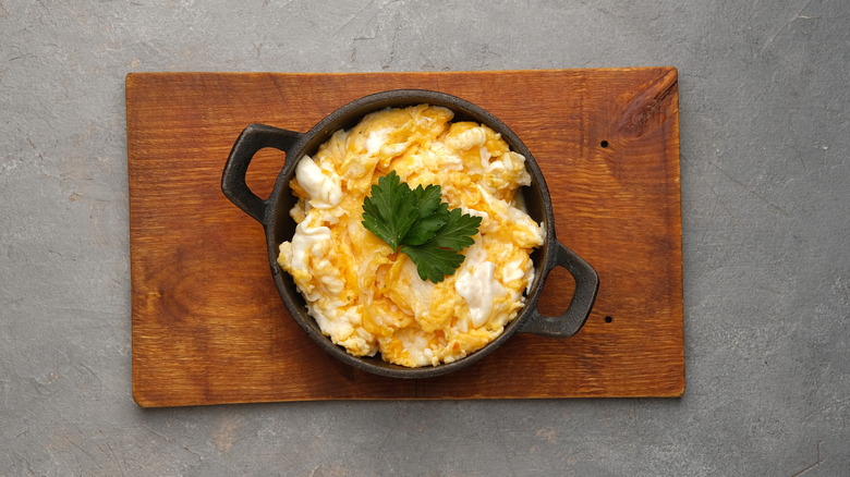 A bowl of soft and creamy scrambled eggs.