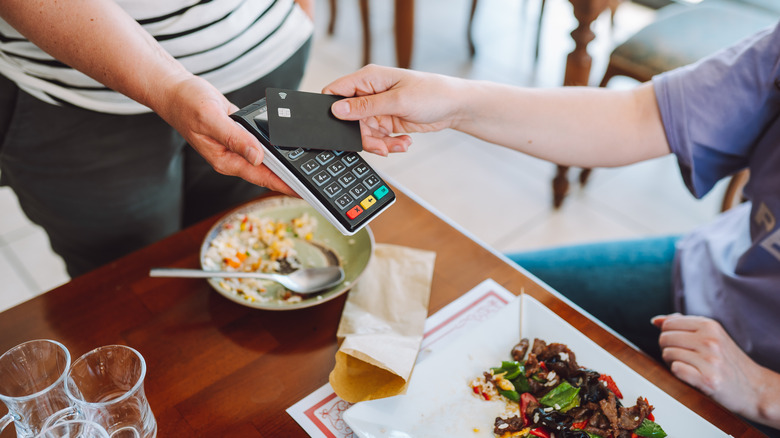 Customer uses credit card on mobile payment device to pay for a meal