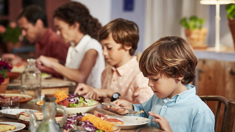 Kids behaving while eating a meal with adults