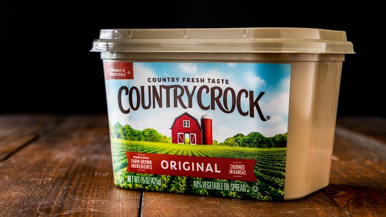 A Country Crock margarine container sits on a wooden surface