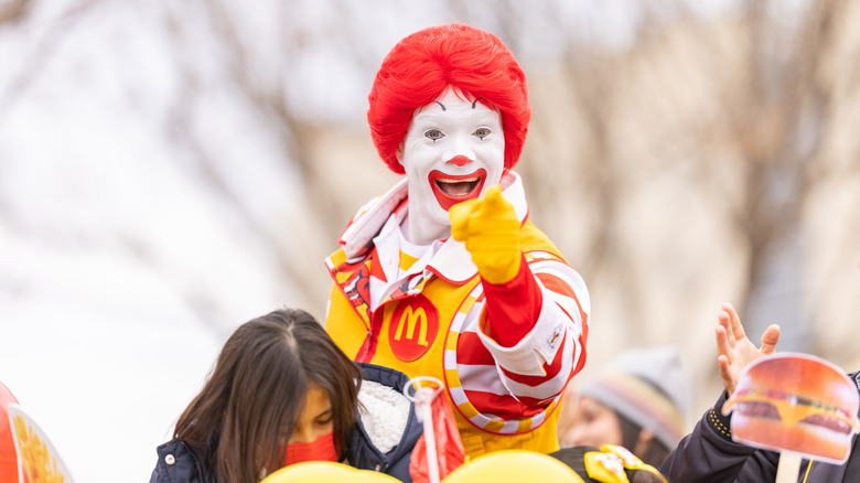 Someone dressed as Ronald McDonald pointing
