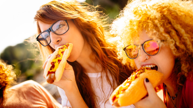 women eating hot dog sandwiches