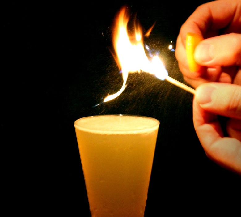 Flaming an orange peel over your cocktail is an easy, impressive bartender trick.