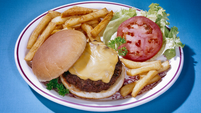 Cheeseburger and fries on a plate shot with a vintage feel