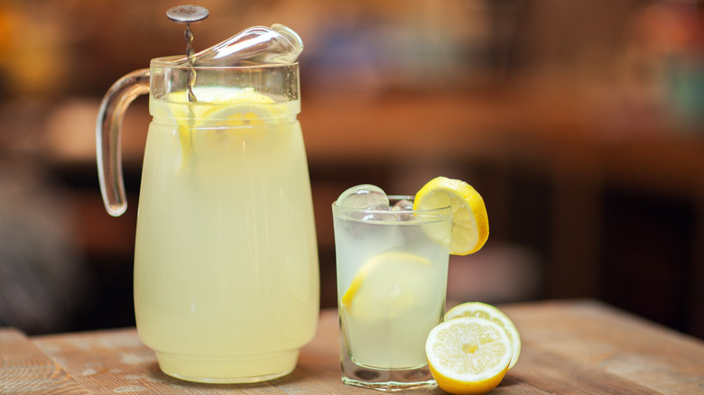 a pitcher and a glass of lemonade