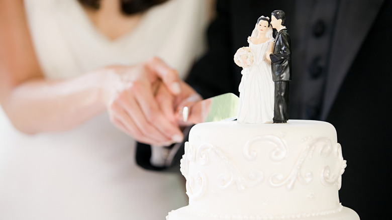 Bride and groom cutting a slice from their wedding day cake