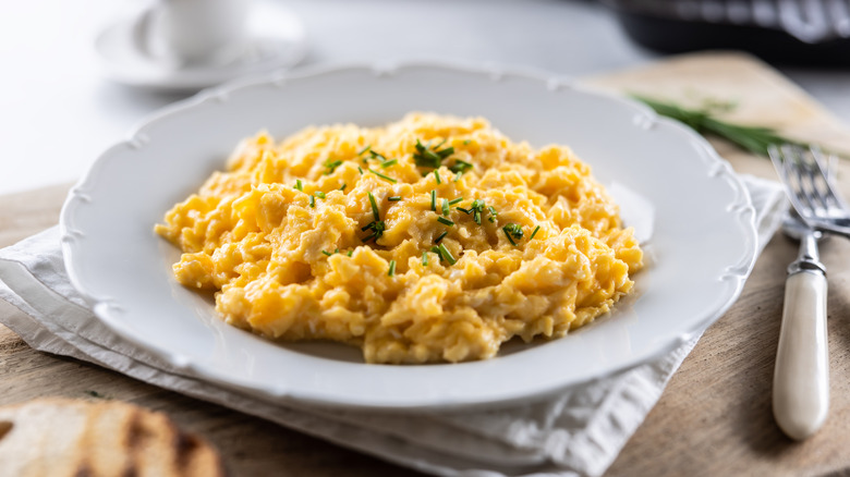 creamy scrambled eggs garnished with green onion