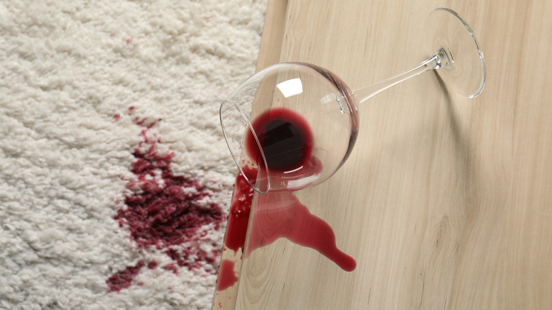 Red wine spilled on white carpet and table