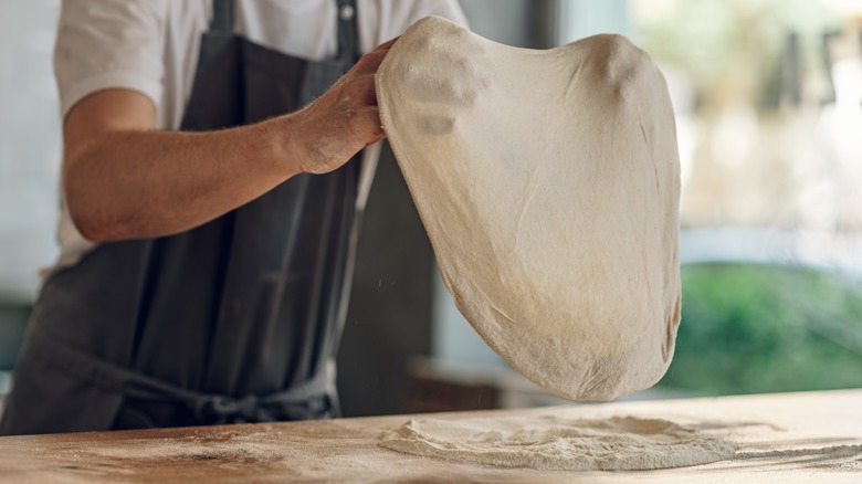Baker stretching bread dough