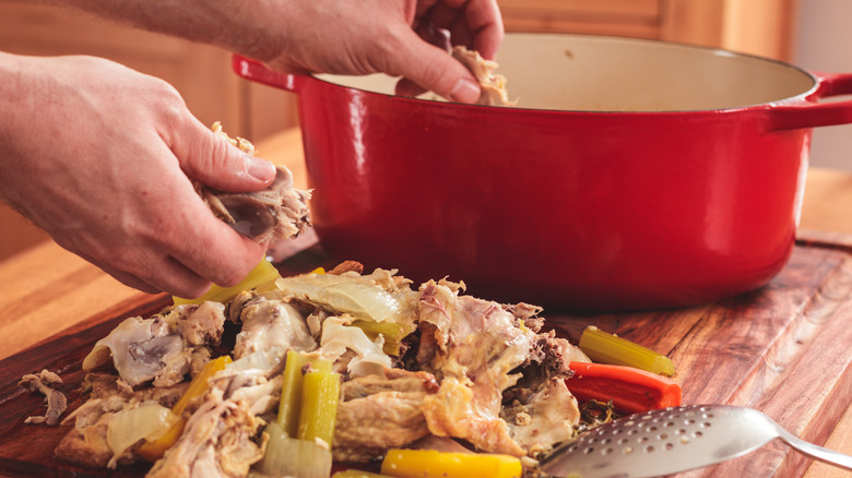 rotisserie chicken on a cutting board next to a pot