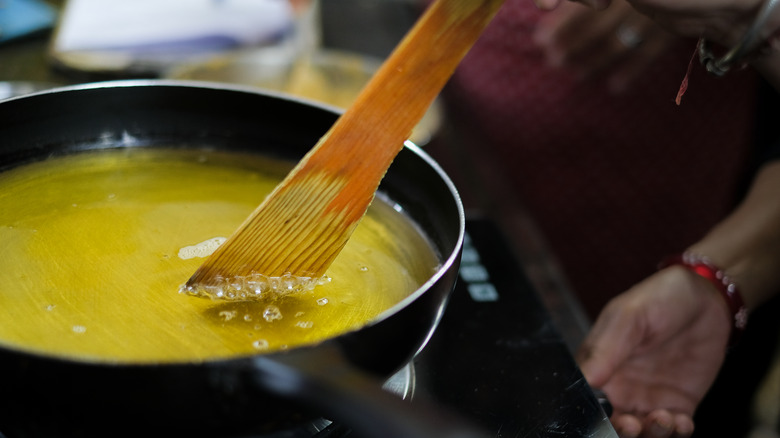 wooden spoon in pan of hot fat