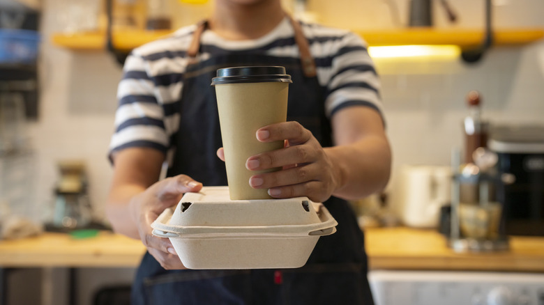 Server with takeout drink and container