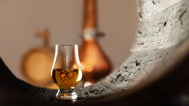 Whiskey glass, barrel, and copper still