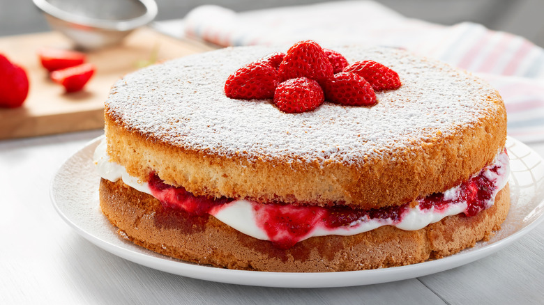 yellow cake with berries and cream on a platter