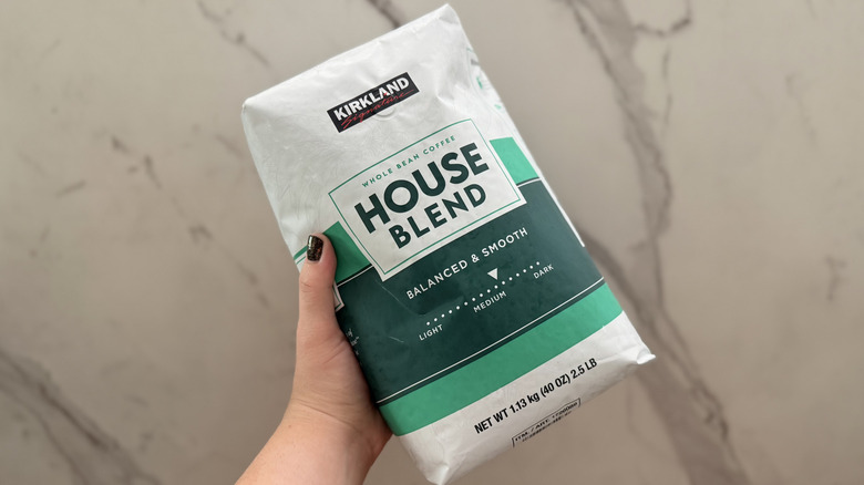 A hand holding the Kirkland House Blend.