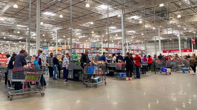 Lots of people are in line at the check-out section of a Costco