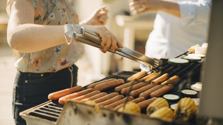person grilling hot dogs