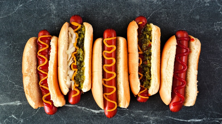 a variety of hot dogs on a black background