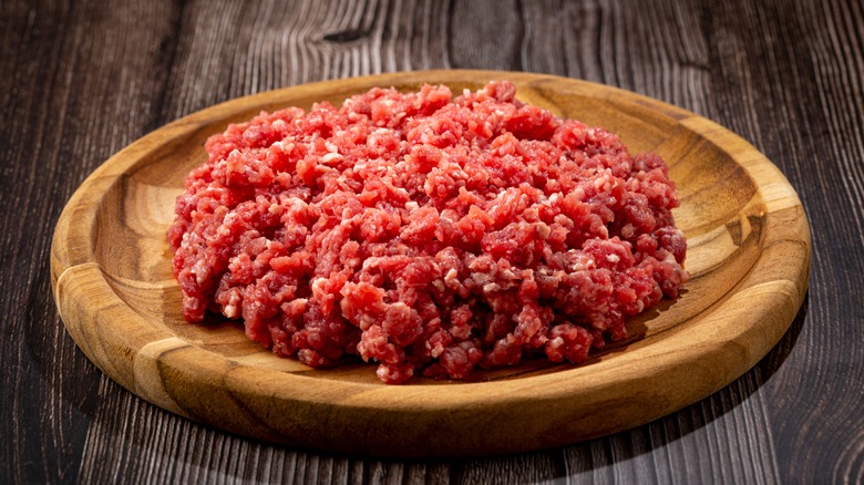 Ground beef in a wooden bowl on a table