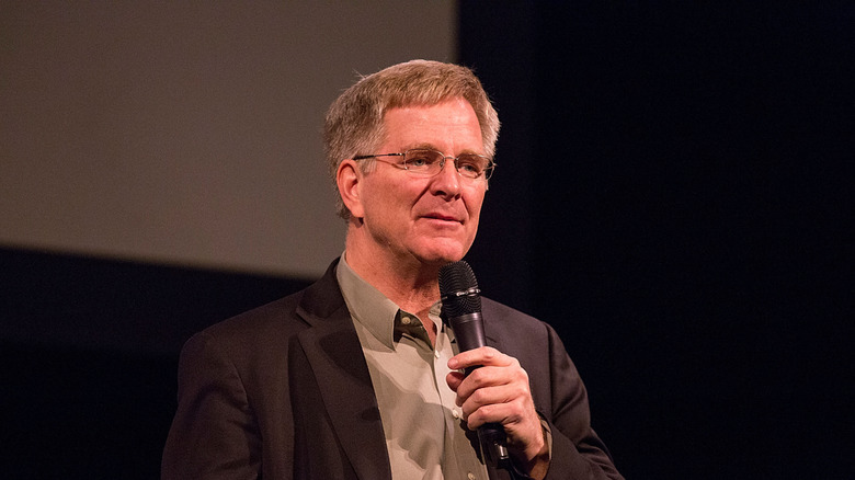 Rick Steves on stage with a microphone