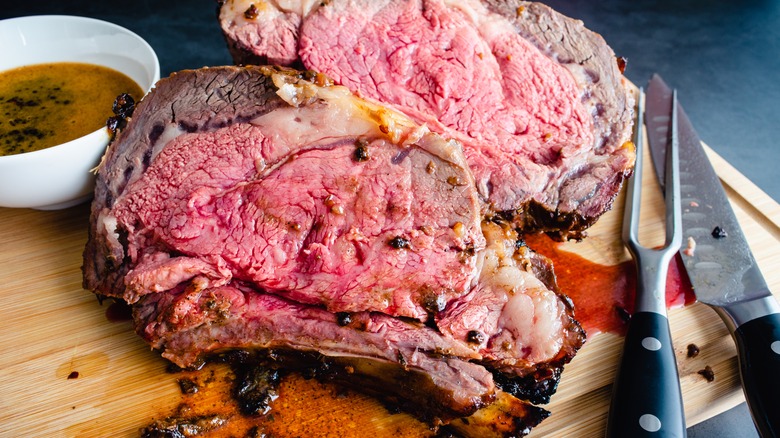 Thick slices of prime rib on cutting board with jus