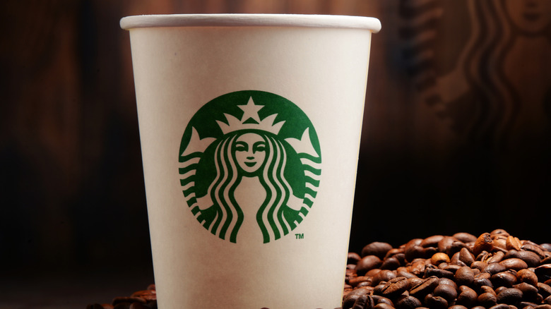 Starbucks cup on table with newspaper