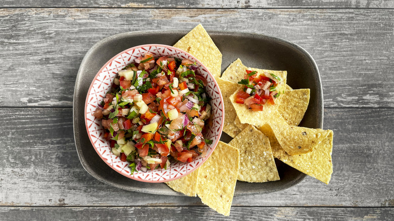 Salsa and tortilla chips on a wooden background