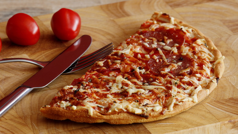 Frozen pizza on cutting board